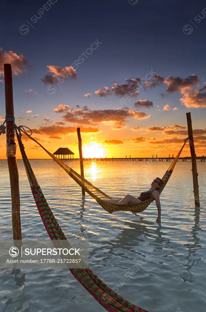 Woman lying in hammock at sunset, Holbox Island, Cancun, Yucatan, Mexico