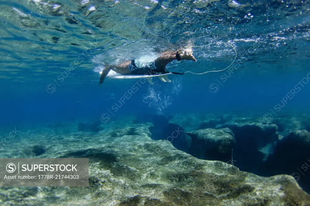 Underwater view of surfer above reef at Pipeline, on North Shore of Oahu, Hawaii, USA