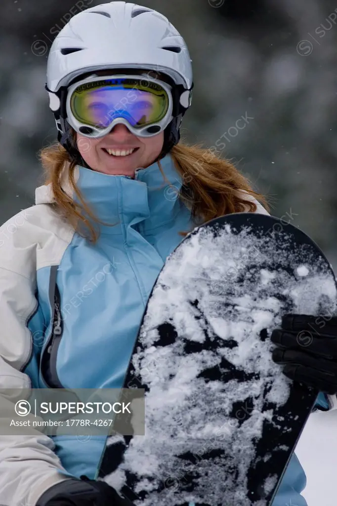 Young woman snowboarding, Sunday River, Newry, Maine.