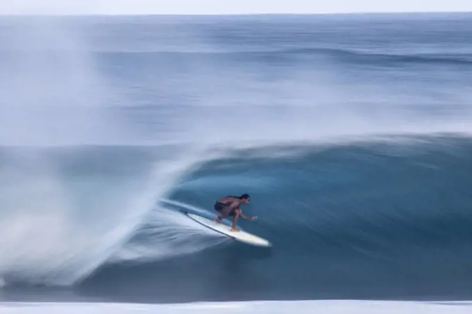 A surfer riding a big wave at the world famous Banzai Pipeline, on the North shore of Oahu, Hawaii.