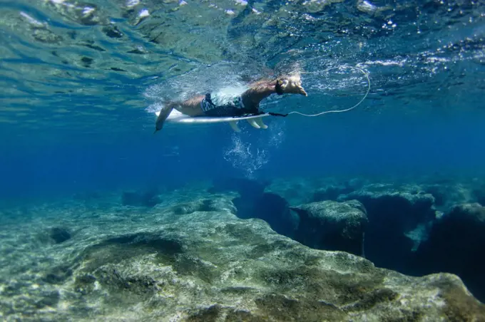 Underwater view of surfer above reef at Pipeline, on North Shore of Oahu, Hawaii, USA