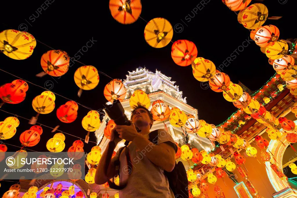 The fantastic lighting of Kek Lok Si Temple and a tourist with a camera; Penang, Malaysia