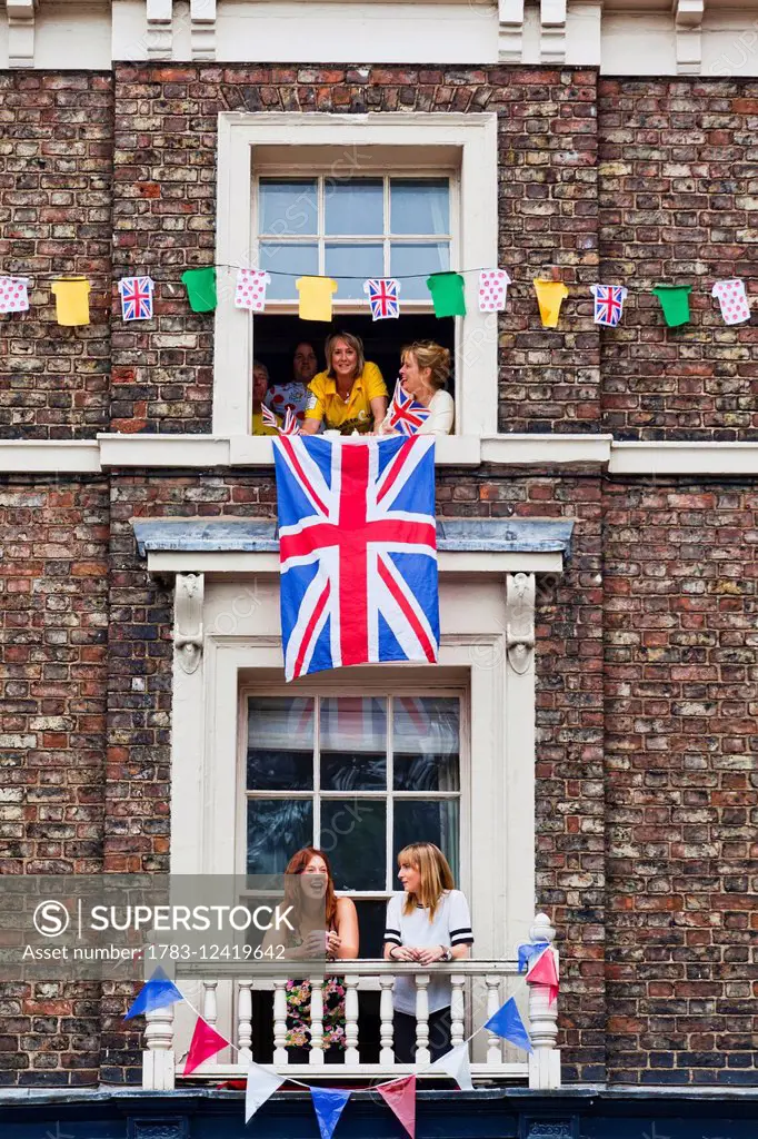 Spectators in windows waiting for the Tour de France; York, England