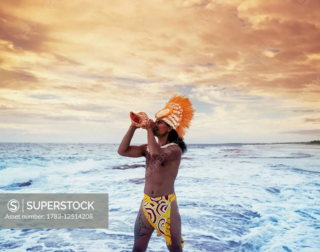 Tahitian man blowing a conche shell; Tahiti