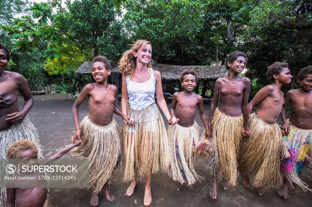 Tourist dances with young girls at Yakel Village; Tanna Island, Vanuatu