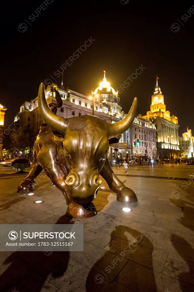 Bund Bull sculpture, a derivative of Arturo Di Modica's Charging Bull, on the Bund at night, Shanghai, China