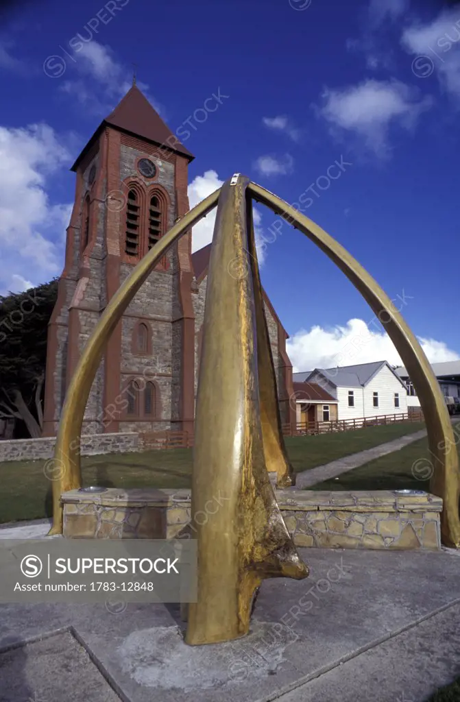 Historic monument, church in background, Whalebone Arch, Stanley Cathedral,  Port Stanley, East Falkland,  Falkland Islands.