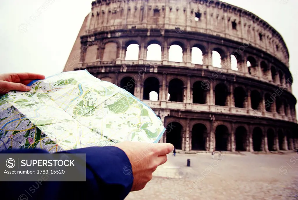 Tourist reading map outside Coliseum, Rome, Italy