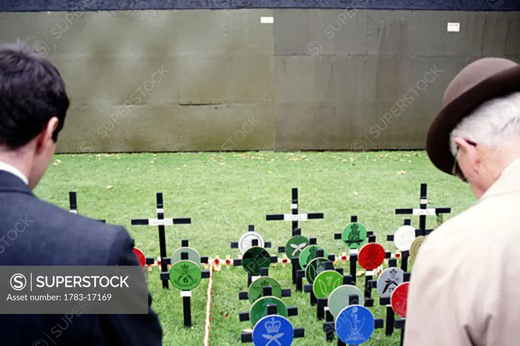 Two men at grave site on Remembrance Day, London, England