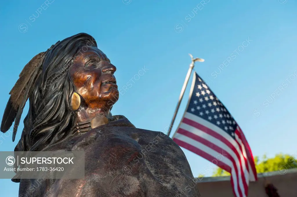 Native American Indian Bronze Statue Next To An American Flag At Friday Night Canyon Road Gallery Walk In Santa Fe, New Mexico, Usa