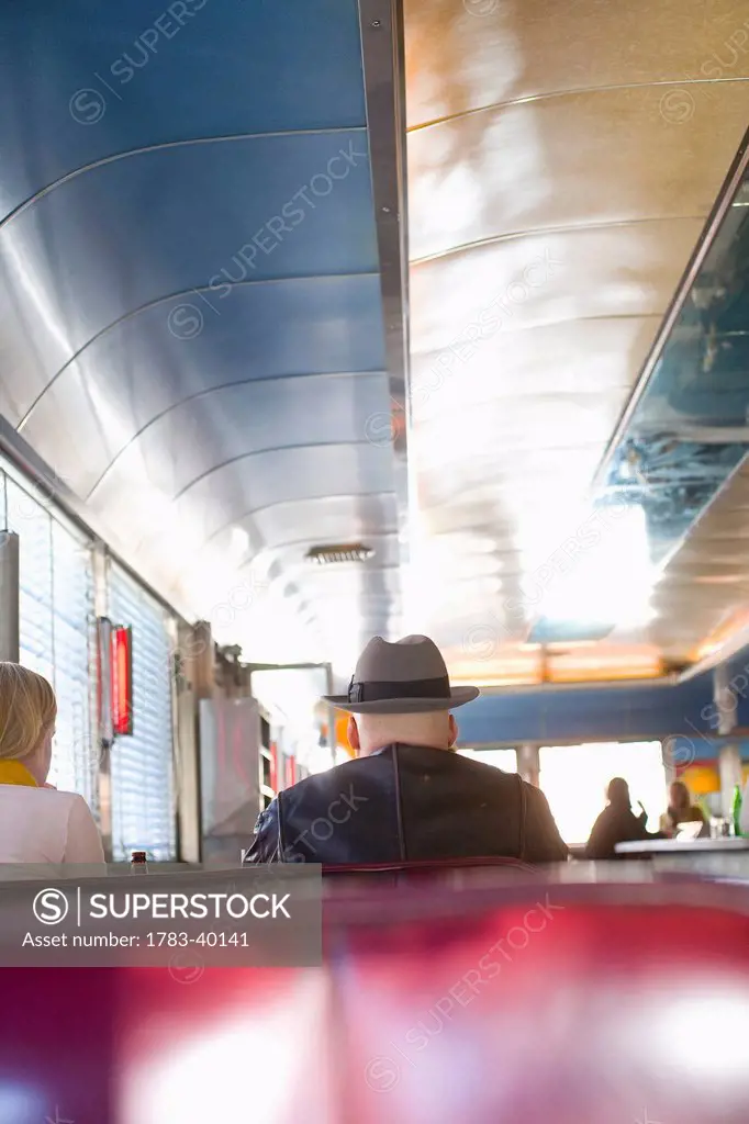 USA, New York State, New York City, Brooklyn, Men eating cheeseburgers at Relish Diner; Williamsburg