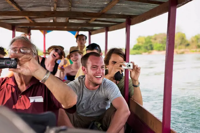 Tourists take a ferry on the Mekong River to the Island of Don Det; Laos