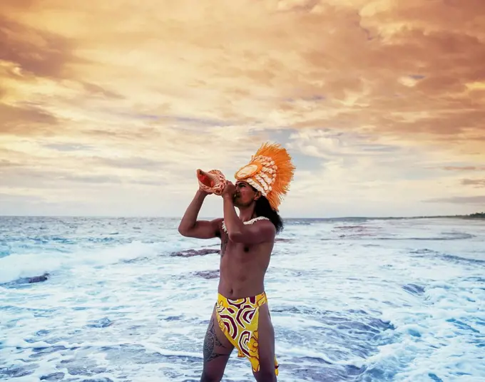 Tahitian man blowing a conche shell; Tahiti