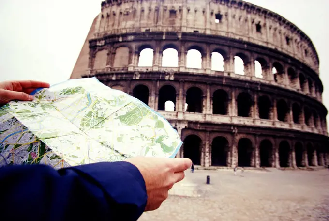 Tourist reading map outside Coliseum, Rome, Italy