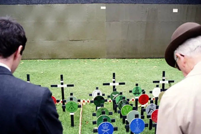 Two men at grave site on Remembrance Day, London, England