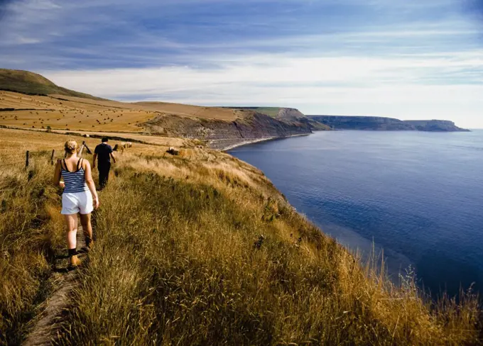 Cauple walking along coastal path, rear view, Purbeck, Dorset, UK.