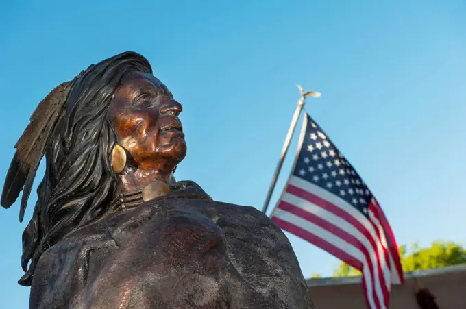 Native American Indian Bronze Statue Next To An American Flag At Friday Night Canyon Road Gallery Walk In Santa Fe, New Mexico, Usa