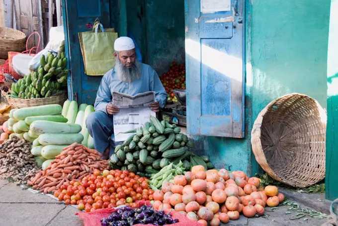 Muslim Vegetable Seller Reading The Newspaper At Devaraja Market In Mysore, Karnataka, India