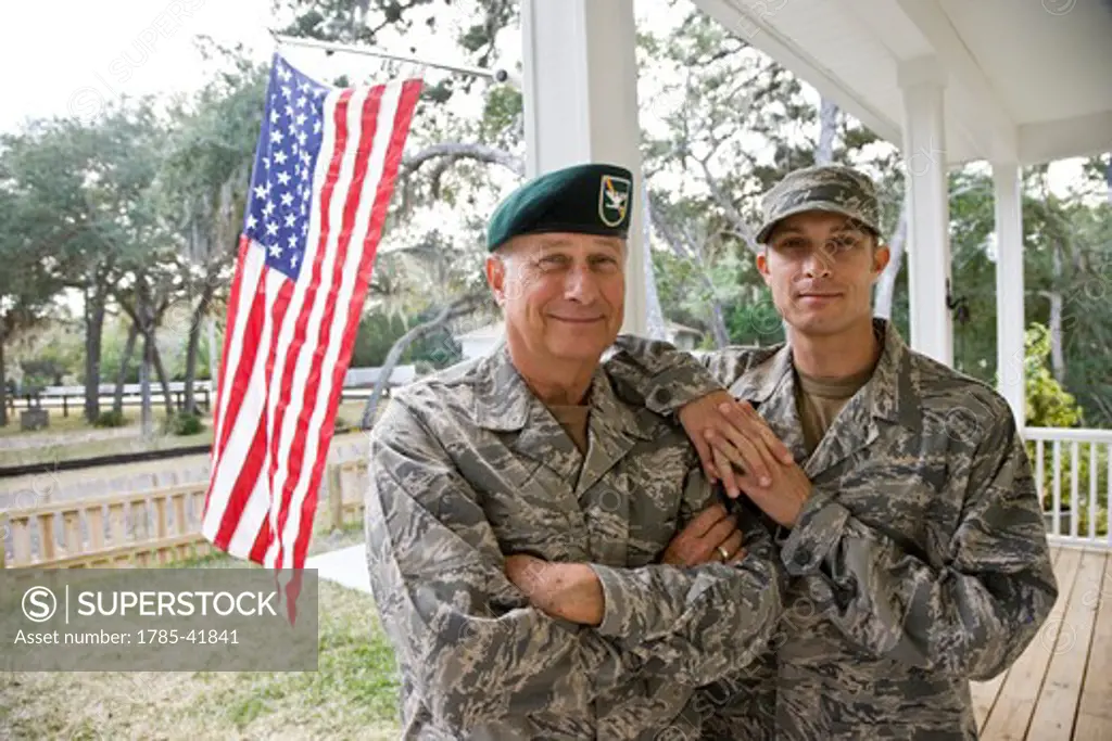 Father and son in military uniforms by American Flag