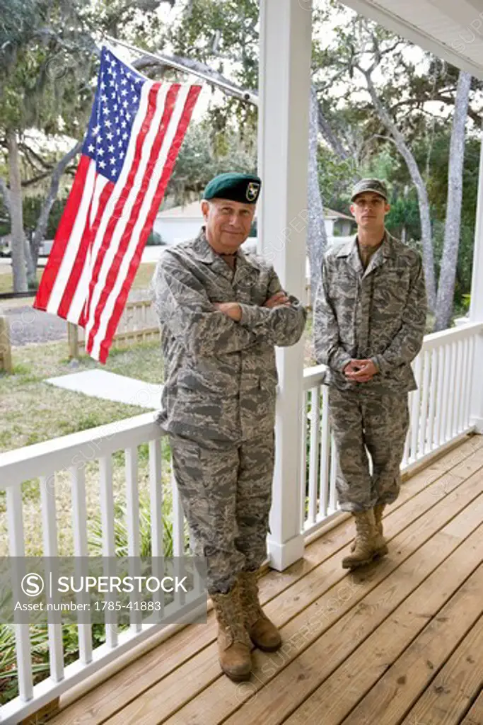 Father and son in military uniforms by American Flag