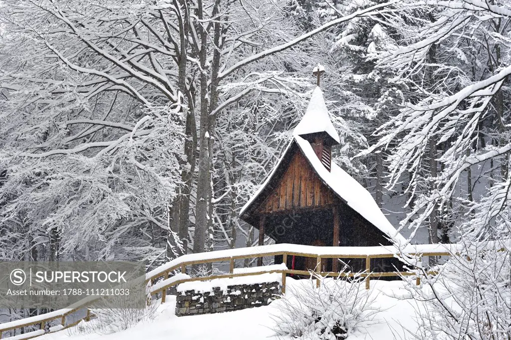 Wooden church in the military cemetery for the soldiers fallen during World War I, in the snow, in Slaghenaufi, Lavarone, Trentino-Alto Adige, Italy.