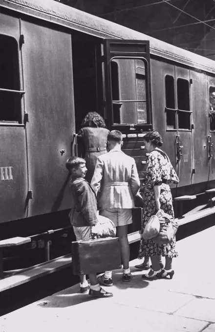 Departure for Ferragosto holidays from Piazza Principe station, a family getting on a third class train carriage, August 14, 1936, Genoa, Italy, 20th century.