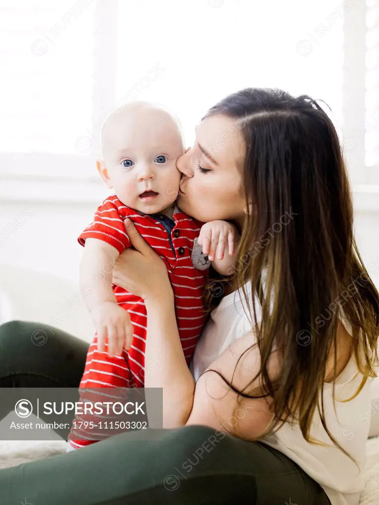 Woman kissing her baby boy's cheek