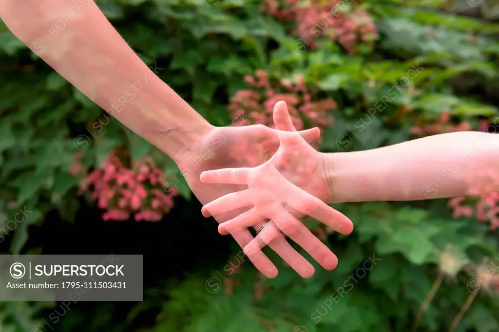 Double exposure of mother and daughter's hands