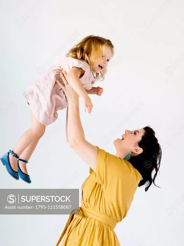 Mother holding her daughter aloft