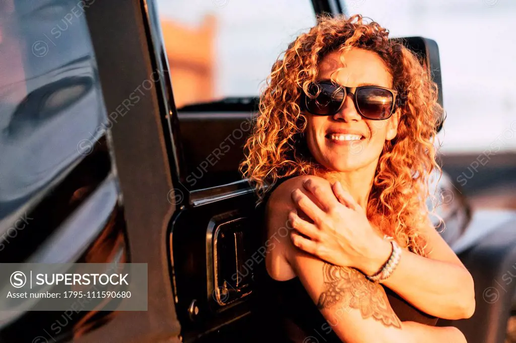 Smiling woman wearing sunglasses with arm tattoo