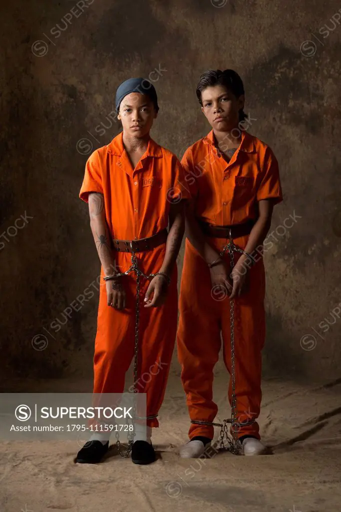 Boys in prisoner jumpsuits and handcuffs