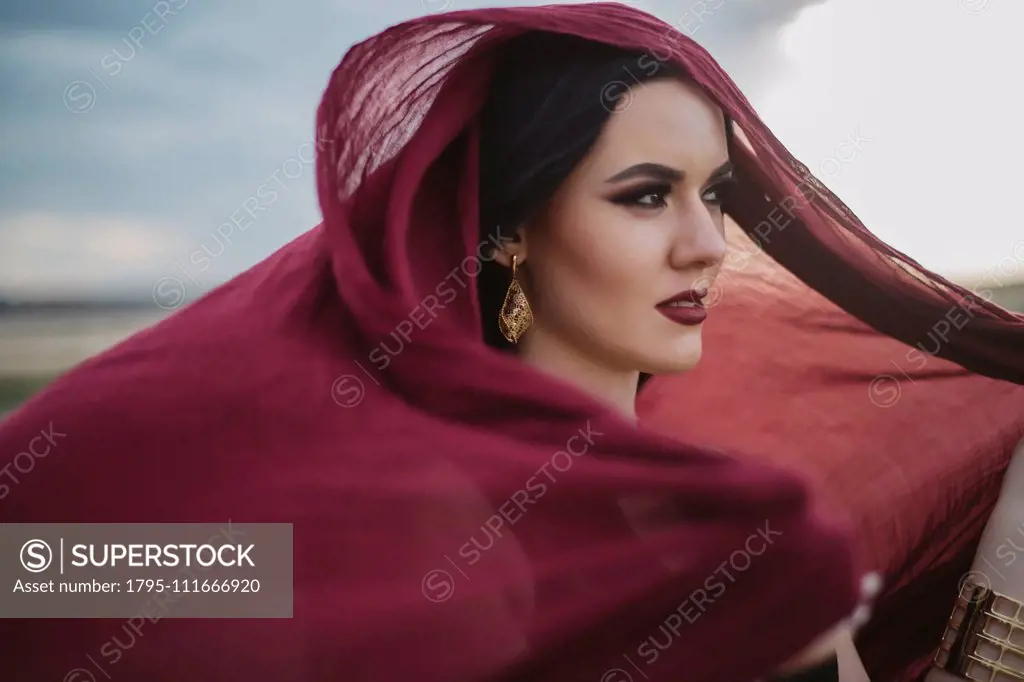 Windswept woman wearing red headscarf and lipstick