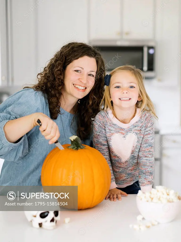 Mother and daughter carving pumpkin for Halloween