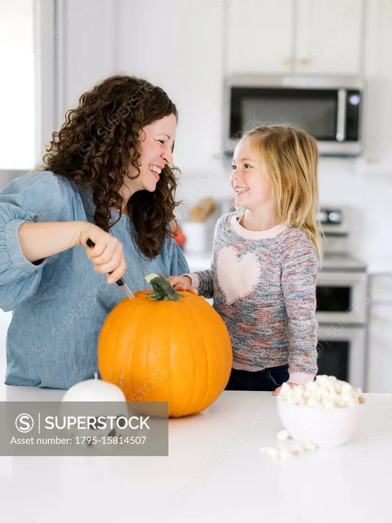 Mother and daughter carving pumpkin for Halloween