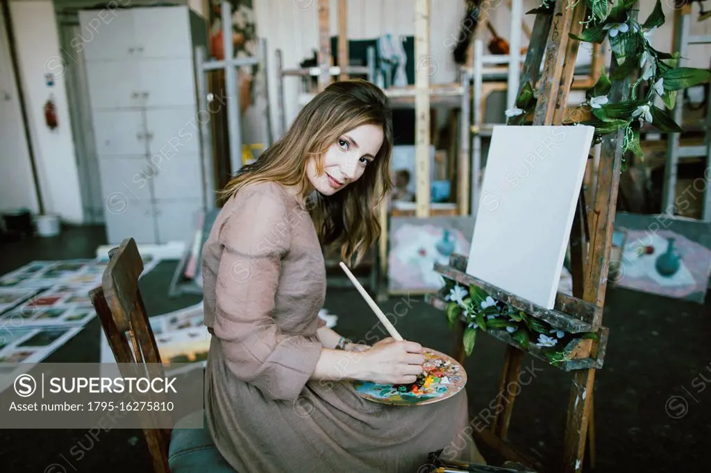 Woman painting on canvas in art studio