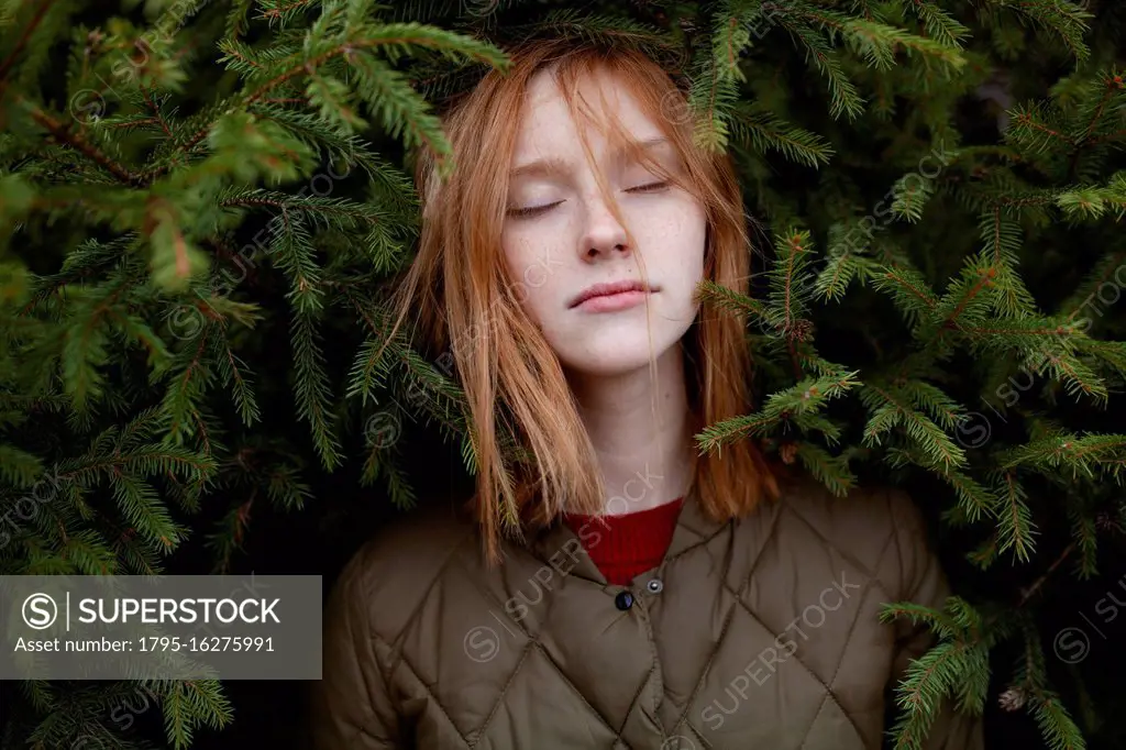 Portrait of young woman in foliage