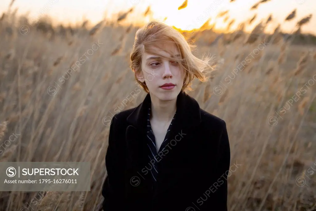 Russia, Omsk, Portrait of young woman in tall grass