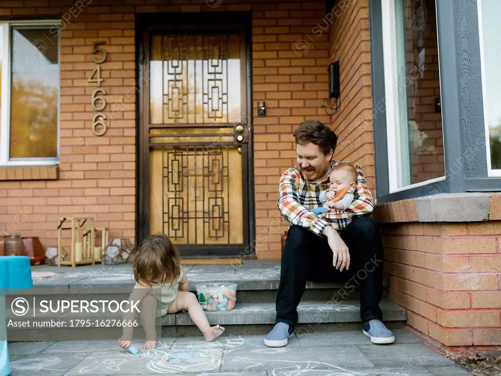 Father with kids sitting on porch