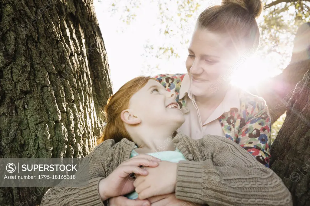 Portrait of mid adult mother and daughter in park