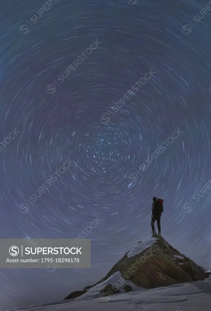 France, Haute Savoie, Chamonix, Mont Blanc, Climber standing on top of Mont Blanc and watching star trails