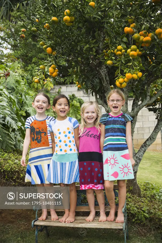 Smiling girls standing on bench