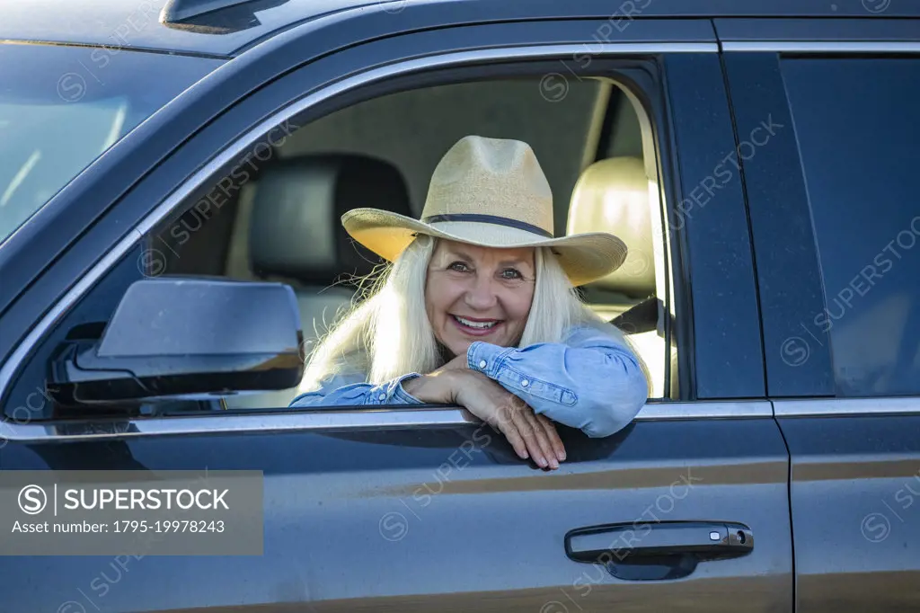 Blonde woman in car wearing cowboy hat