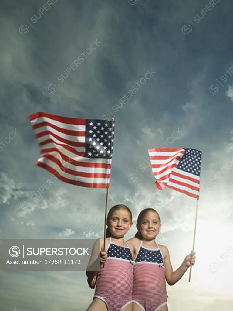 Two young sisters holding American flags