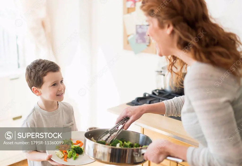 Mother and son (6-7) serving healthy dinner