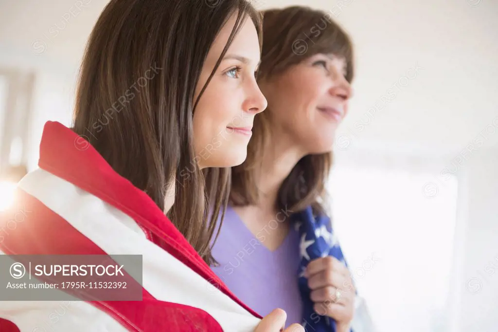 Teenage girl (14-15) and her mom wrapped in American Flag on Fourth of July