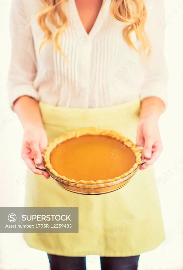 Woman holding pumpkin pie