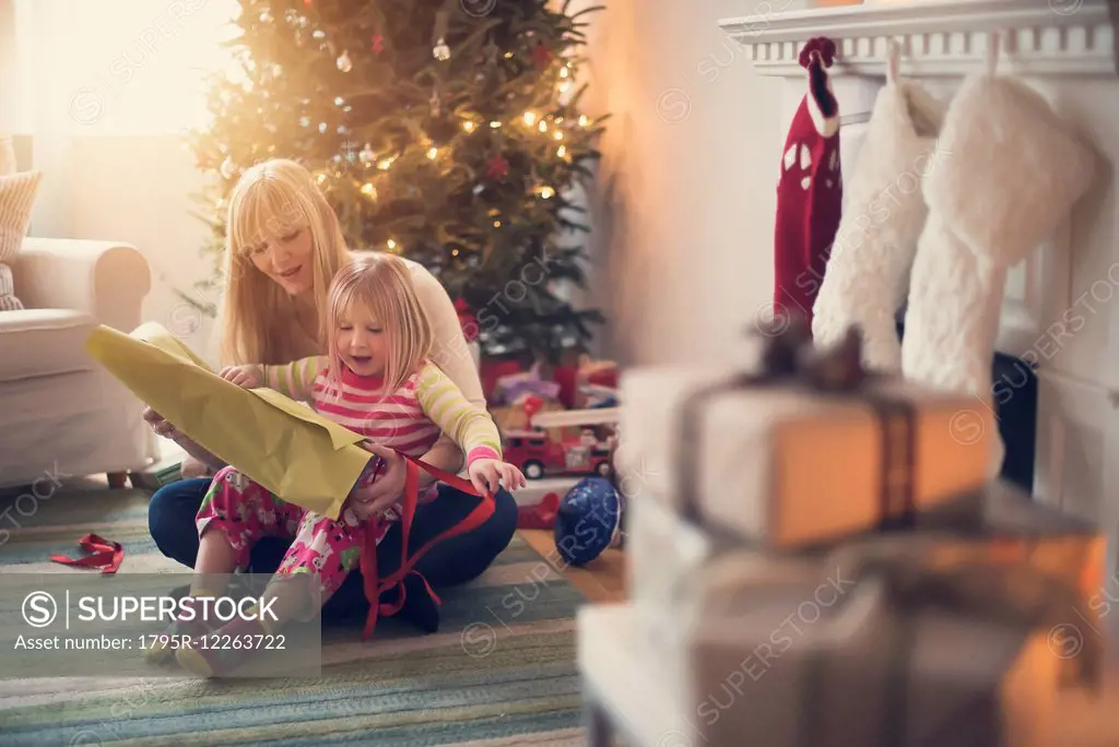 Mother and daughter (4-5) opening christmas presents