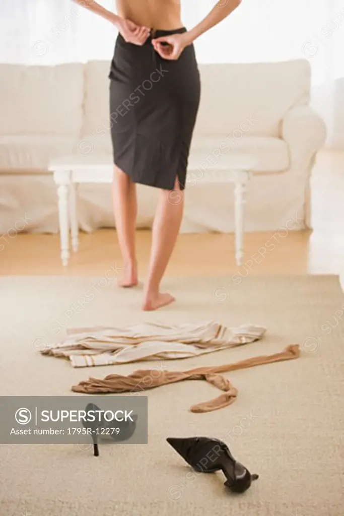 Woman undressing next to clothing on floor