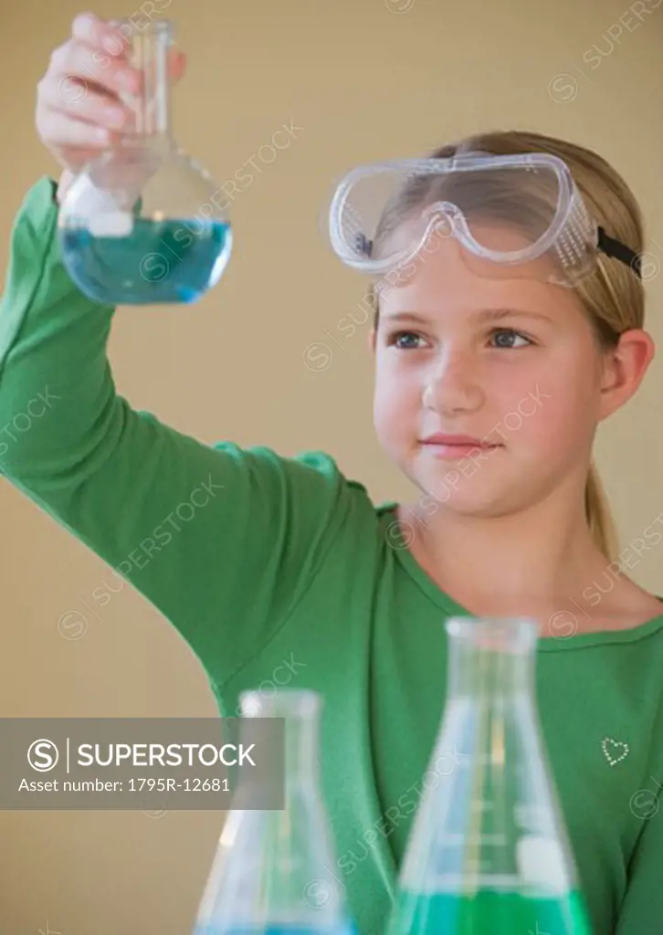 Girl in science class looking at beaker