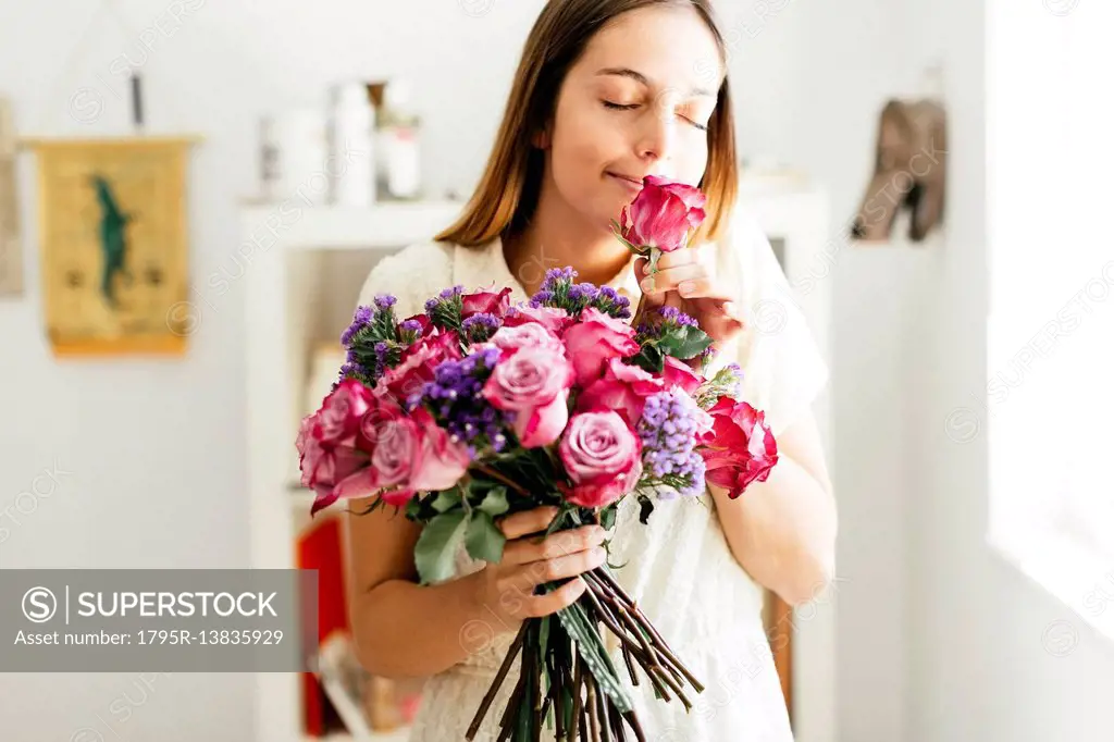 Woman smelling bouquet of roses